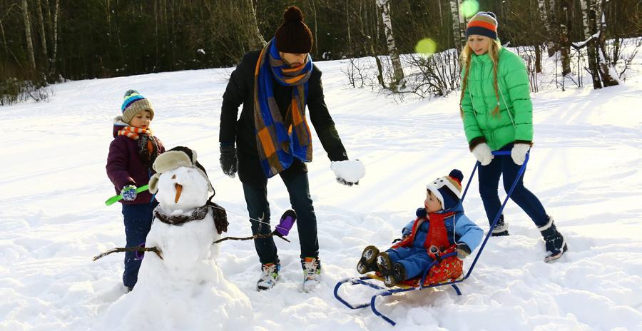 Een gezin dat in de sneeuw speelt